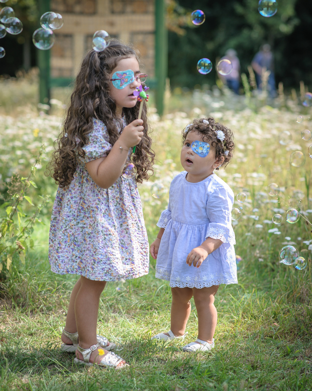 Zwei Mädchen mit ORTOPAD® auf der Wiese machen Seifenblasen