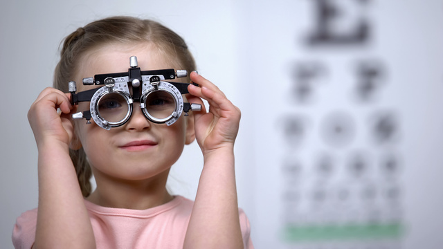 Mädchen mit Messbrille vor Sehtafel 